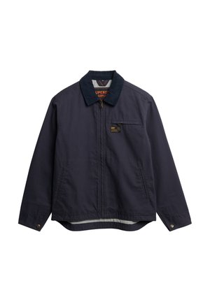 Marineblauwe jas met een corduroy kraag, voorrits en borstzak. Heeft een gestreepte binnenvoering en knoopsluiting bij de mouwen.