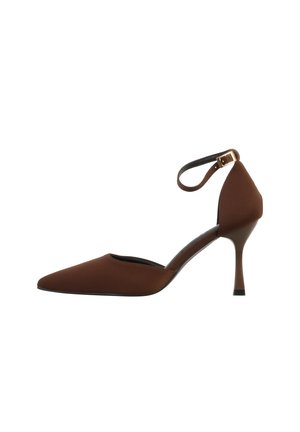 Bruine hoge hak met puntige neus, een smalle hak en een enkelbandje dat is vastgemaakt met een kleine gouden gesp, weergegeven op een witte achtergrond.