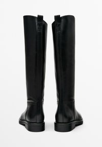 Černé kožené kozačky ke kolenům s hladkou texturou, zaoblenou špičkou, nízkým podpatkem a poutky na horní části pro snadné nazouvání.