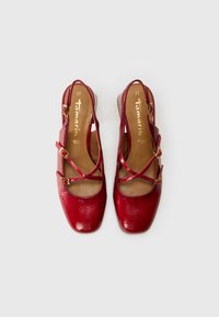 Chaussures plates en cuir verni rouge avec un bout carré, des lanières croisées et des boucles dorées. Taille 37. Fini texturé avec un léger éclat.