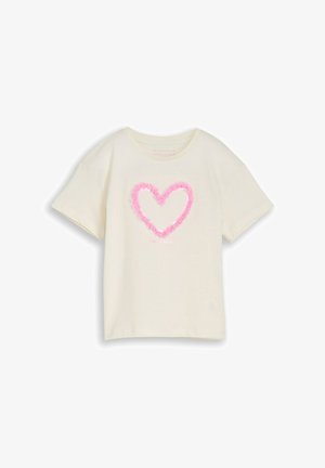 T-shirt beige clair à manches courtes avec un design de cœur rose texturé centré sur la poitrine.