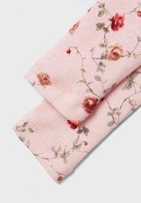 Gaiši rozā audums ar ziedu rakstu, kurā redzamas sarkanas rozes un zaļas lapas. Materiālam ir mīksta, teksturēta virsma.