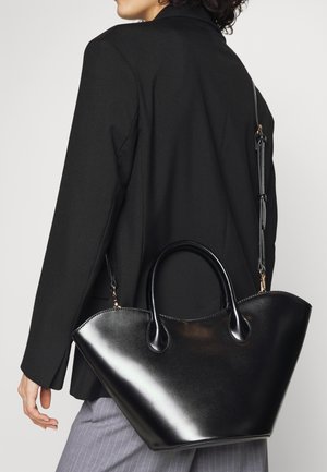 Zwarte leren handtas met een gestructureerd, hoekig ontwerp, een gladde textuur, dubbele handgrepen en een afneembare schouderband, verfraaid met gouden hardware.