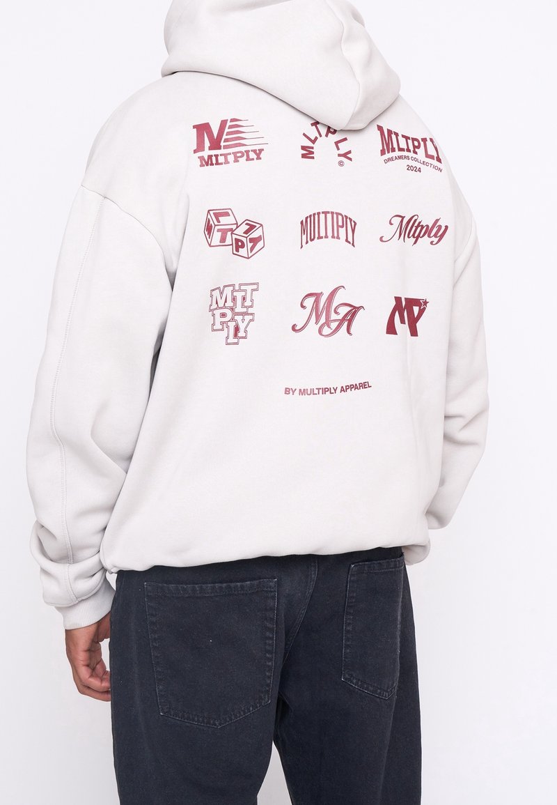 Grijze hoodie van katoen met verschillende bedrukte logo's in donkerrood, voorzien van een capuchon met trekkoord en geribde manchetten. Zwarte broek met zakken.