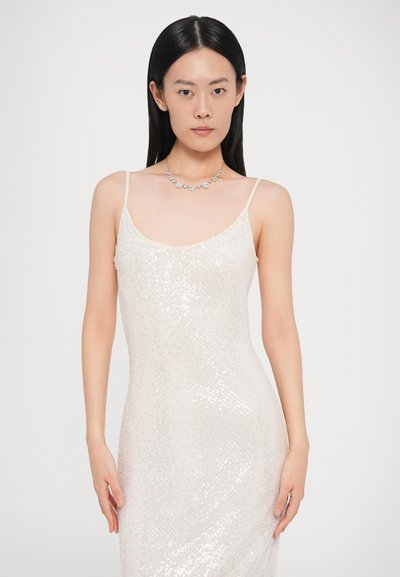 Rochie de seară cu paiete, bej deschis, cu bretele tip spaghetti reglabile. Silueta mulată prezintă o suprafață netedă, texturată, cu detalii strălucitoare.