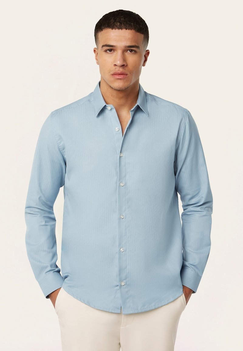 Lichtblauwe lange mouwen shirt van een gladde stof, met een knoopsluiting aan de voorkant, een puntige kraag en een subtiele verticale textuur.