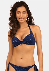 Niebieski bikini składający się z wiązanego topu na szyję w metalicznym krojowym wzorze oraz odpowiednich spodenek z wiązaniem po bokach. Gładka faktura, klasyczny design.