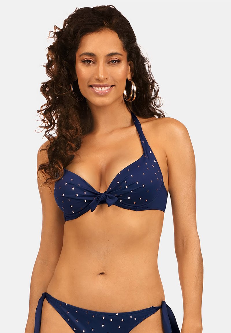 Niebieski bikini składający się z wiązanego topu na szyję w metalicznym krojowym wzorze oraz odpowiednich spodenek z wiązaniem po bokach. Gładka faktura, klasyczny design.