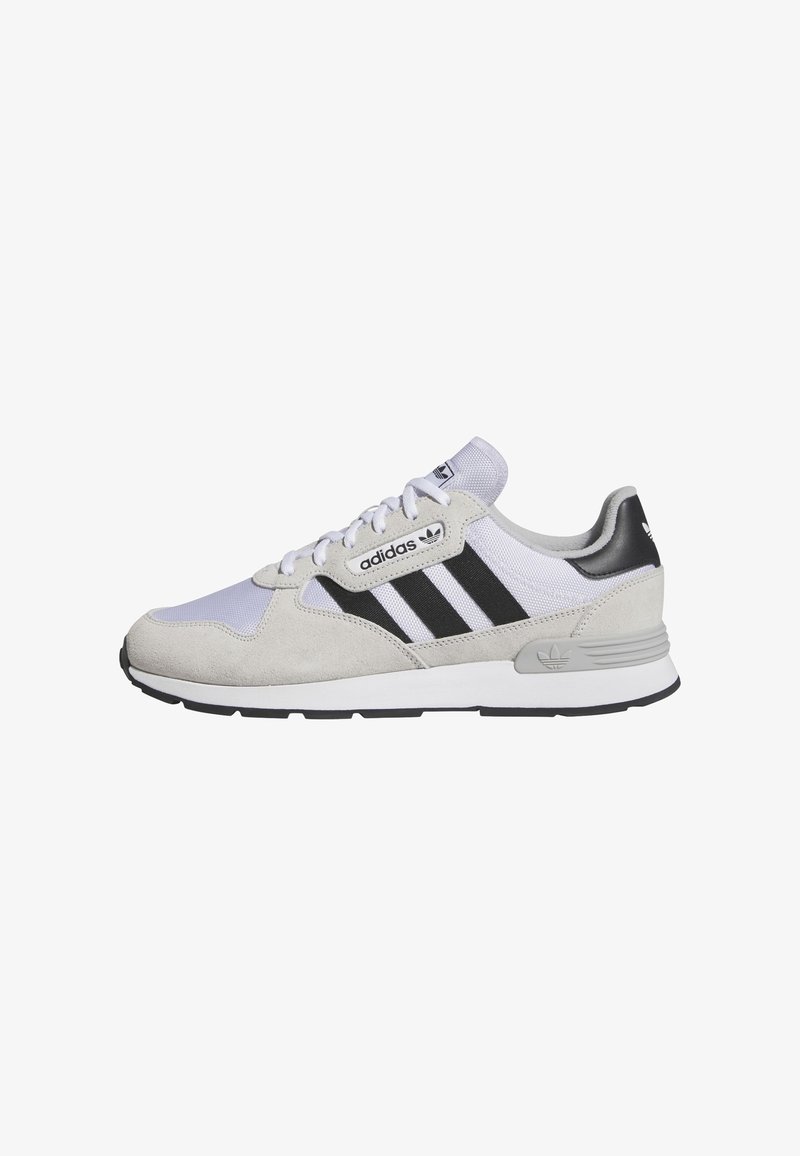 Baskets Adidas avec un dessus en suede gris et en mesh blanc, des rayures noires, une pointe ronde, un design à lacets, et une semelle en caoutchouc noire et grise.
