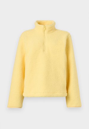 Soft yellow fleece pullover with long sleeves and a short front zipper under a high collar on a plain background.