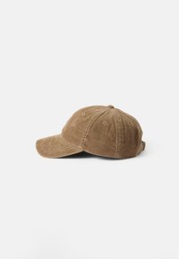 Brun kordflod baseballkeps med en böjd skärm, strukturerad krona och justerbart band bak. Har en vertikal ribbad textur.