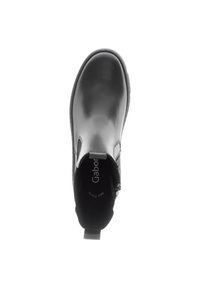 Bottine noire en cuir avec une finition lisse, élastique sur le côté, bout arrondi et tirant texturé au talon. Nom de la marque inscrit sur la semelle intérieure.