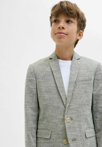 Ljusgrå blazer i texturerat tyg, med enkelknäppt design, slagkrage och två framfickor. Knappdetalj som accentuerar stilen.