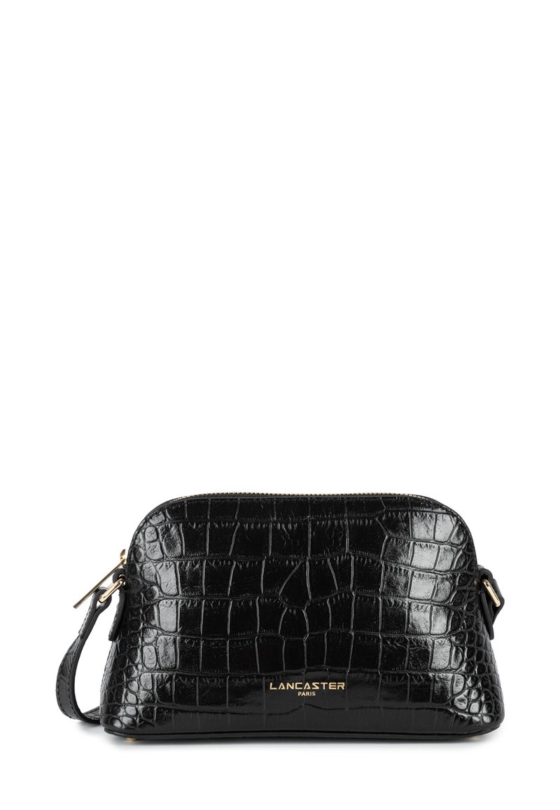 Sac en cuir verni noir avec une texture crocodile, fermeture éclair et une bandoulière amovible. Présente un logo doré sur le devant.