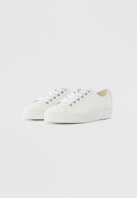 Baskets en toile blanche avec embout rond, semelle en caoutchouc, œillets métalliques et lacets plats blancs. Design simple avec une texture lisse.