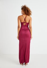Μαξι φόρεμα από βουργουνδί σατέν με σταυρωτές τιράντες, λεπτομέρεια κλειδώματος στην πλάτη και εφαρμοστή σιλουέτα. Λείο υφή και λεπτομέρειες ραφής.