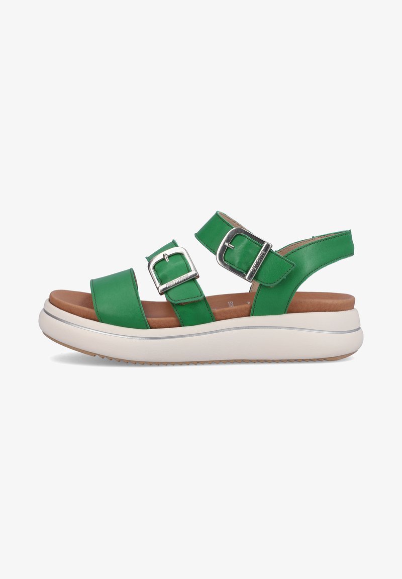 Sandales en cuir vert avec deux sangles réglables, boucles métalliques et une semelle plate blanche présentant un fond texturé pour une meilleure adhérence.