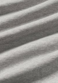 Tissu gris avec une texture douce et lisse, présentant de légères rayures horizontales et un design léger et extensible.
