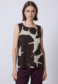 Haut sans manches en tissu léger avec un motif abstrait de feuilles marron et crème agrémenté d'accents rouges et un col rond.
