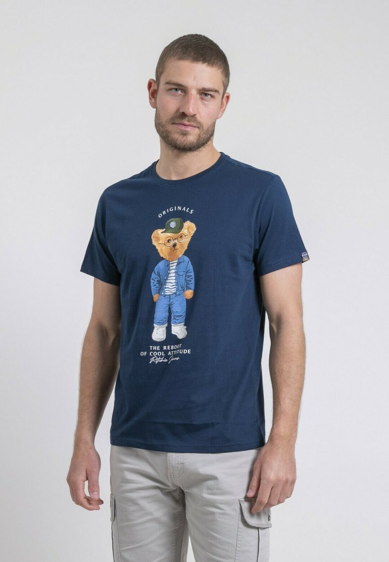 T-shirt en coton navy avec un graphique de dessin animé d'un ours portant des lunettes et une tenue bleue. Manches courtes et col rond.