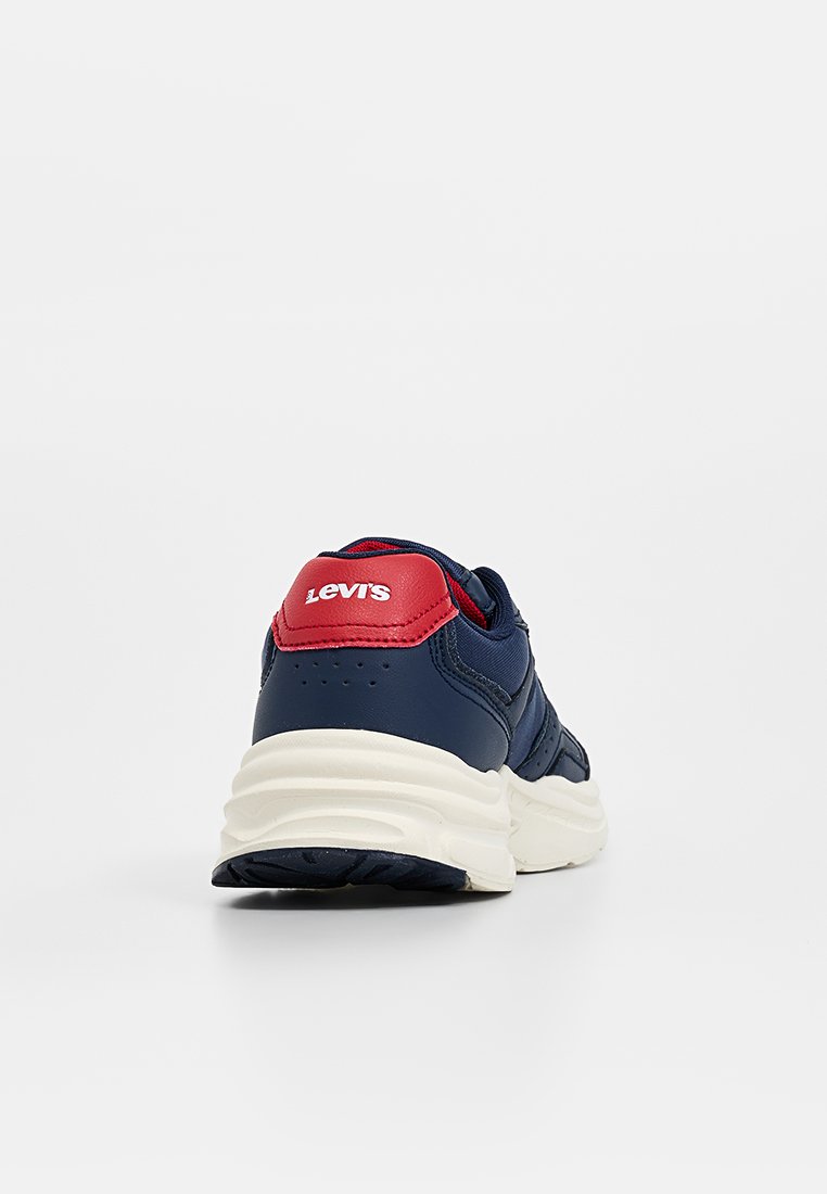 Zapatilla azul marino con parte superior de cuero texturizado, media suela blanca y acento en el talón rojo con el logo de "Levi's". Suela de goma para mayor agarre.