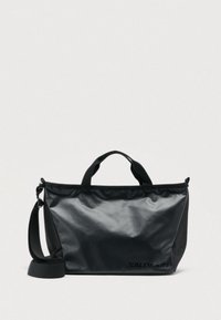 Μαύρη τσάντα με γυαλιστερό φινίρισμα, ορθογώνιο σχήμα, εξωτερικό λογότυπο, κοντά χερούλια και αφαιρούμενο ιμάντα ώμου για πολλαπλούς τρόπους μεταφοράς.