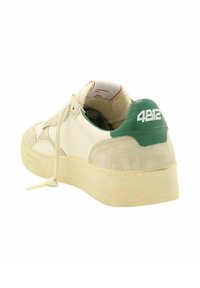 Sneaker con una parte superiore in pelle bianca, dettagli in suede beige, punta arrotondata e un tassello verde sul tallone con il testo bianco "4B12". Chiusura con lacci piatti.