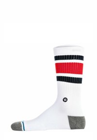 Weiße Socken mit strukturiertem Rippenmuster, versehen mit roten und schwarzen horizontalen Streifen und einer grauen Ferse. Schwarzes Logo am Knöchel.