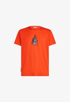 Orange bomulds t-shirt med et gråt bjørne grafik med en rygsæk og ski. Rund halsudskæring og korte ærmer, blød tekstur.