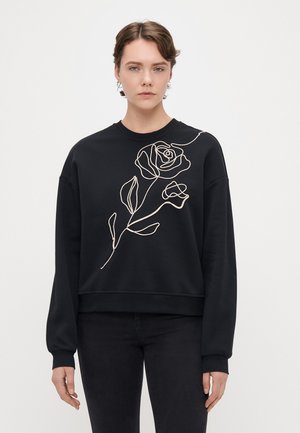 Sweatshirt preto com mangas longas, apresentando um design de rosa bordada em creme na parte da frente. Tecido macio, corte solto, decote redondo.