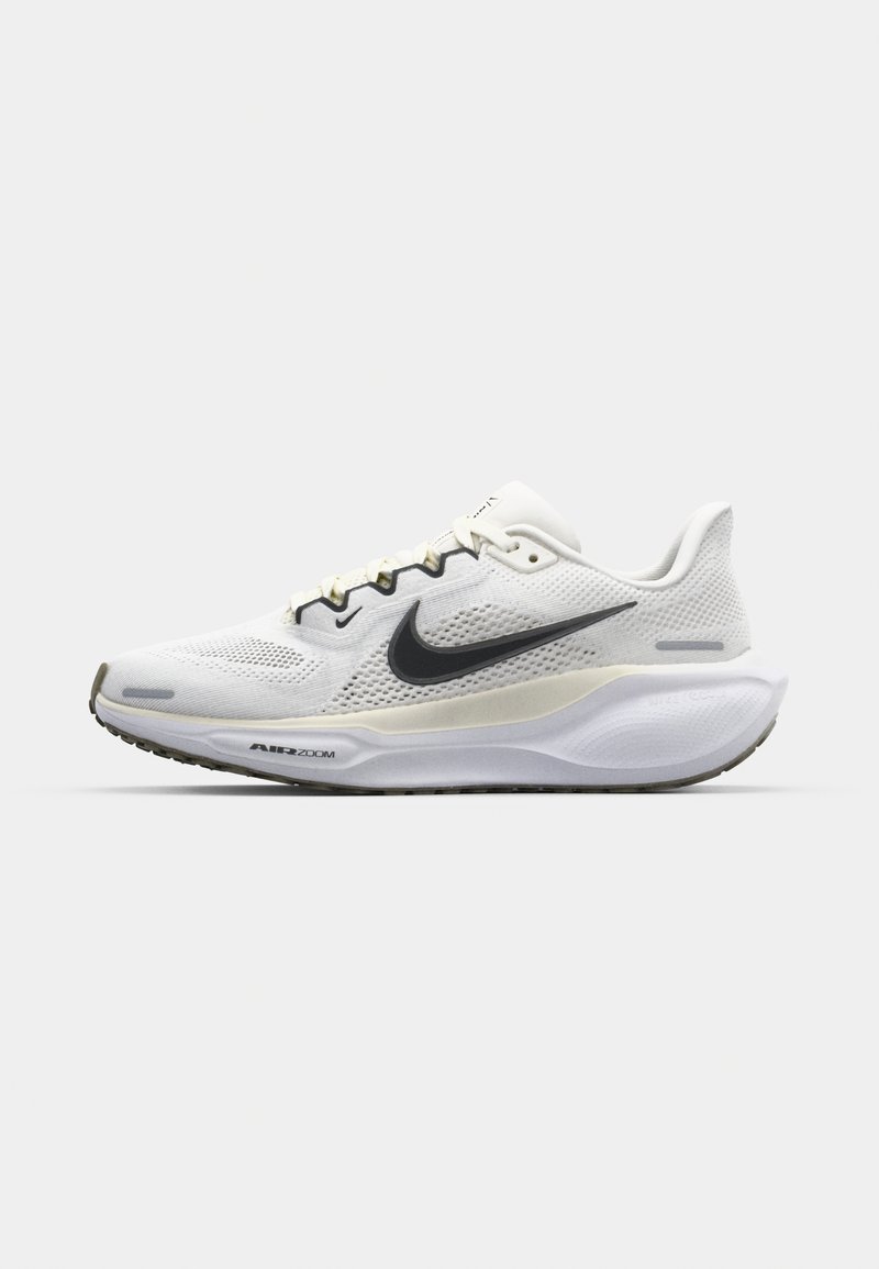 Zapatilla de running de malla blanca con acentos en negro, punta redondeada, suela acolchada y suela texturizada. Presenta tecnología Air Zoom visible.