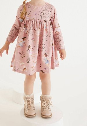 Rosa långärmad klänning med blommiga och fétrymder, samlad midja och en utsvängd kjol. Matchad med beige snörstövlar med pälsdetaljer.