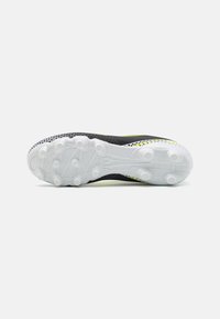 Le scarpe da calcio presentano una tomaia nera con accenti gialli, un design texturizzato e una suola in gomma bianca con tasselli circolari per una maggiore trazione.