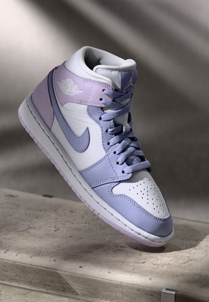 Baskets montantes Air Jordan en blanc, lavande et violet clair avec lacets, logo Nike swoosh et logo Air Jordan à la cheville.