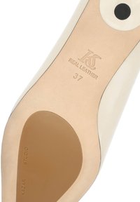 Semelle d'une chaussure en cuir beige de taille 37, embout de talon rond noir, avec la marque "Kazar Studio" embossée sur la semelle.