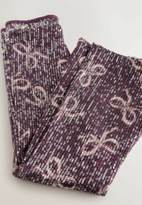 Lila szövet leggings flitteres mintával, világos rózsaszín masnival díszítve. Texturált felület, elasztikus derékpánttal.