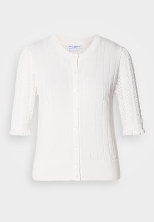 Valkoinen neuletakki, jossa on ribbikuviointi, lyhyet puffihihat, joissa on pitsiyksityiskohtia, nappikiinnitys ja pienet röyhelöt hihansuiden kohdalla.