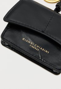 Sort læderpunge med en glat tekstur, der har en fold-gennem klap, guld logo "GIANNI CHIARINI FIRENZE" og et minimalistisk design.
