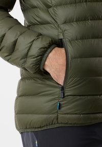 Grønne pufferjakke med quiltet struktur, lynlåslomme på siden og elastiske manchetter. Stoffet virker glat og let.