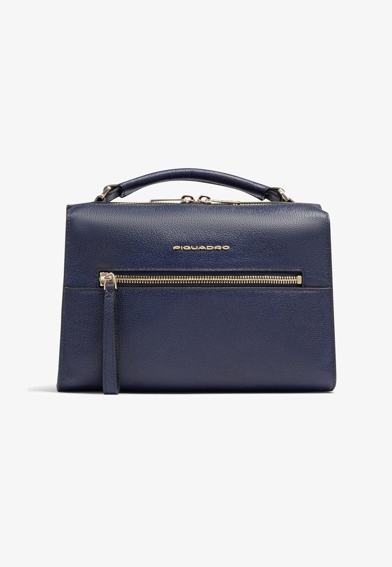 Bolso de cuero azul marino con asa superior, bolsillo frontal con cremallera y lengüeta vertical, y logo "Piquadro" en tono dorado centrado sobre el bolsillo.