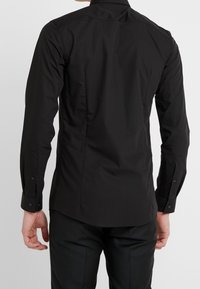 Zwarte lange mouwen shirt met een getailleerd ontwerp, een gladde textuur en knopenmanchetten. Heeft een klassieke kraag en een rechte zoom.