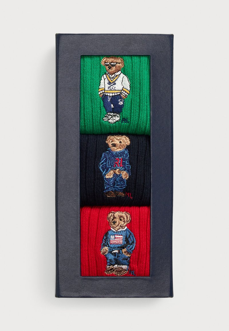 Pack of three knitted socks in green, navy, and red, each featuring an embroidered bear in different clothing styles.