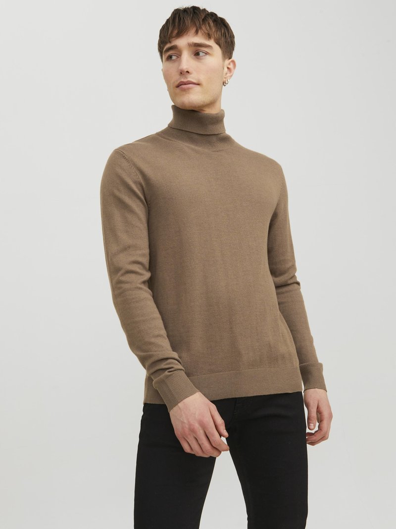 Brauner Rollkragenpullover aus weichem, glattem Material mit langen Ärmeln und gerippten Bündchen. Kombiniert mit schwarzen Hosen, bietet er eine taillierte Silhouette.