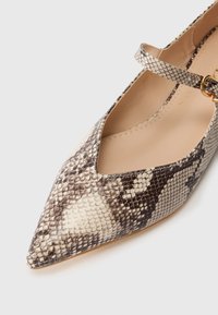 Scarpa flat a punta con motivo in rettile beige e nero e una sottile cinghia chiusa da una piccola fibbia dorata.