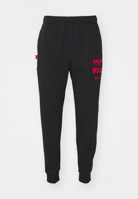 Sorte joggebukser laget av mykt stoff, med rød "BULLS"-tekst og Nike-logo, med elastisk midje og ribbestrikkede ankler.