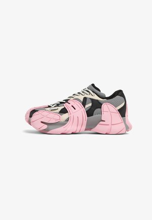 Multicolored sneaker featuring a mesh upper in gray and beige with black accents, a chunky pink sole, and a distinctive tactile design.