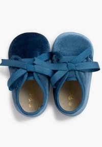 Scarpine per bambini in velluto gradient blu con una consistenza morbida, punte arrotondate e nastri coordinati con texture che si annodano sulla parte superiore del piede.