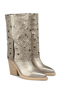 Goldfarbene metallische Knöchelstiefel mit einem geometrischen Ausschnittdesign und Nietenakzenten. Sie verfügen über eine spitze Zehenform und einen klobigen Holzabsatz.