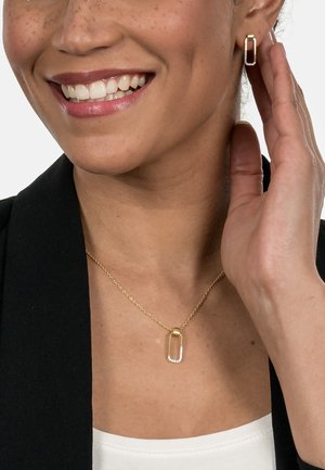 Gold-tone necklace with a rectangular pendant featuring a crystal accent. Matching hoop earrings in a similar design. Smooth metal texture.