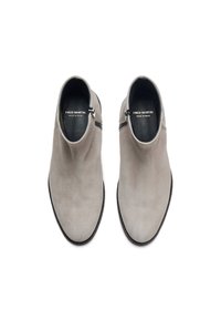 Botines de ante gris con cierre de cremallera, superficie lisa, puntera redondeada y suela delgada negra. Etiquetados "FRED MARTIN, HECHO EN ESPAÑA."